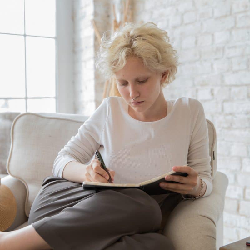 Woman journaling about how to find balance in life and set boundaries.